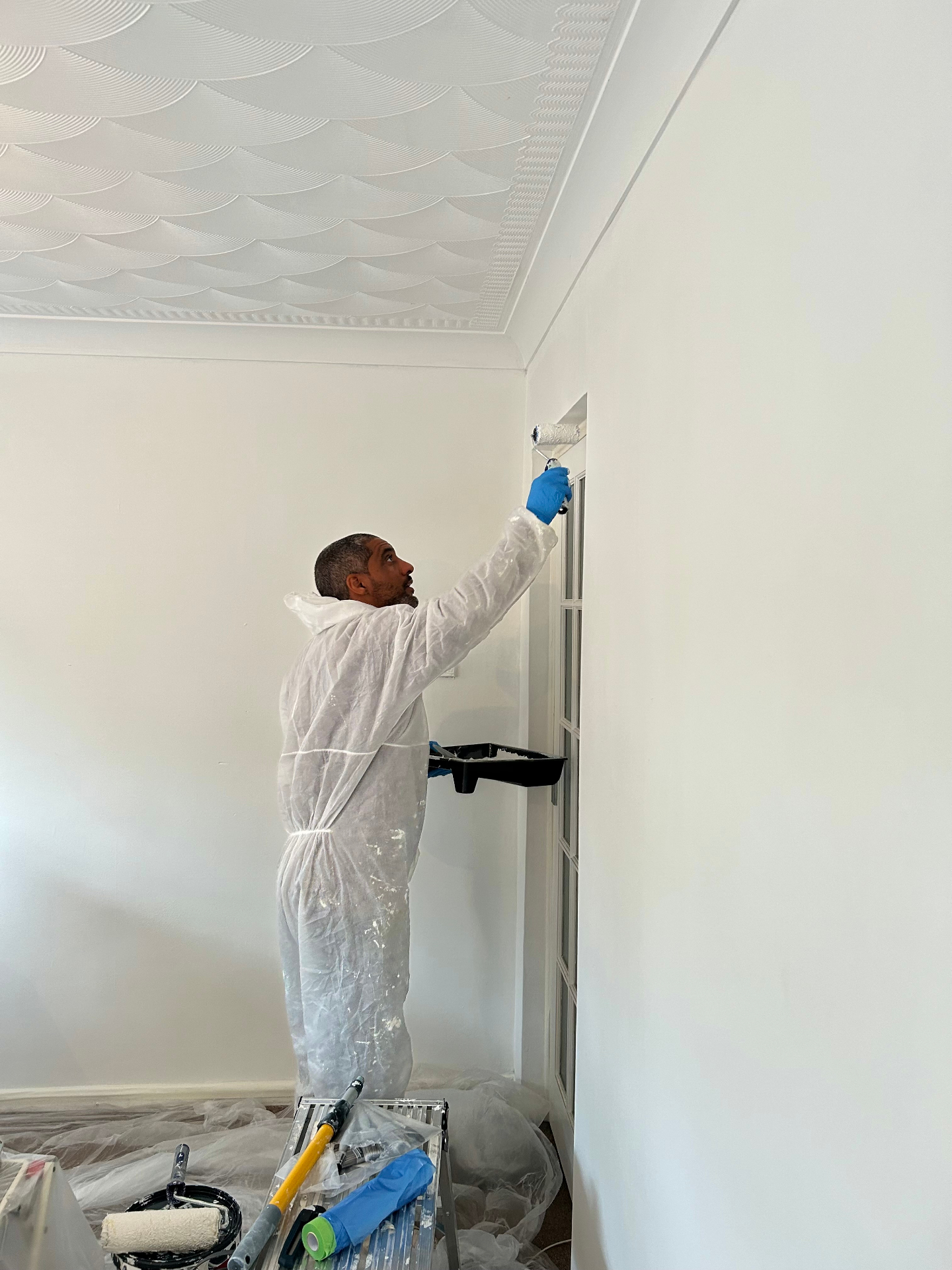 OUTTUU painting an interior in a Bedfordshire village home, dust-sheeted and prepped